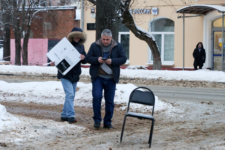 Подольск, 9 января 2024 года. Местные жители несут обогреватель в разгар крупной аварии, оставившей городские учреждения и жилые дома без тепла и горячей воды