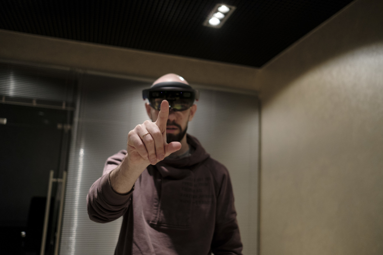 Михаил Кириченко, директор по развитию HoloGroup, в очках HoloLens. Фото: Антон Карлинер для Republic
