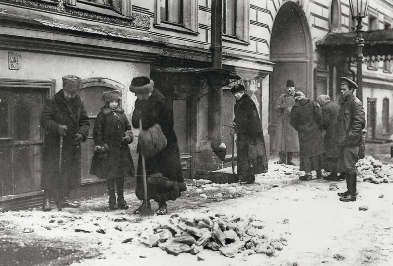 Петроградская «буржуазия» занята очисткой тротуаров от снега. Большевистский Декрет о трудовой повинности от 5 октября 1918 г. устанавливал для «буржуазных элементов», в число которых входила бóльшая часть интеллигенции (в том числе научной), обязательные и неоплачиваемые общественные работы.