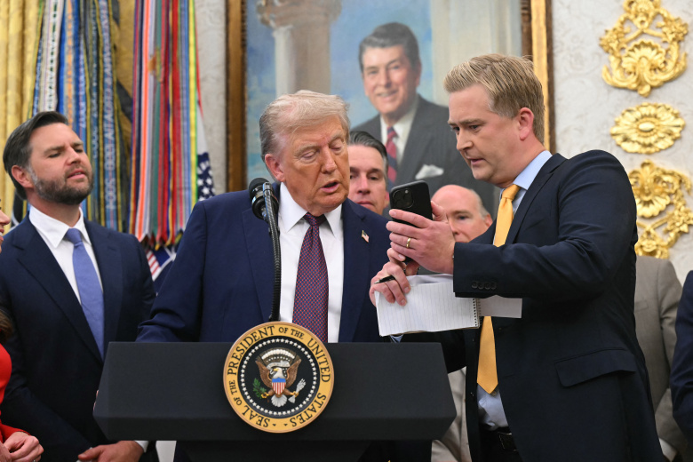 Репортер Fox News Питер Дуси показывает президенту США Дональду Трампу что-то на своем смартфоне. Возможно, нейрослопы. свой телефон