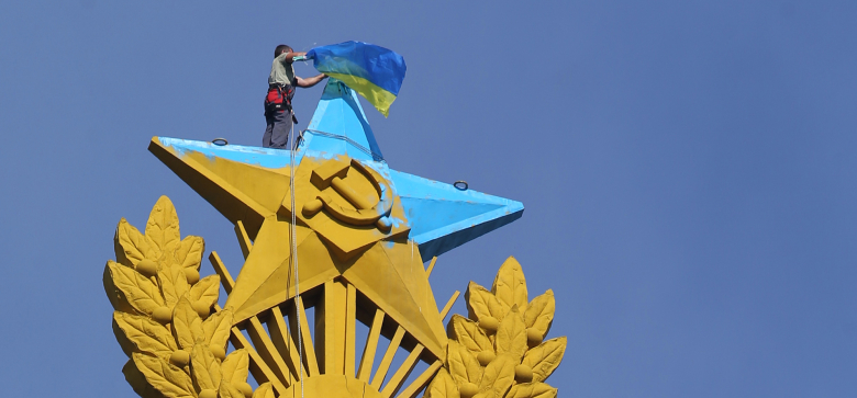 Звезда, раскрашенная в цвета флага Украины, и флаг Украины на жилом доме на Котельнической набережной.