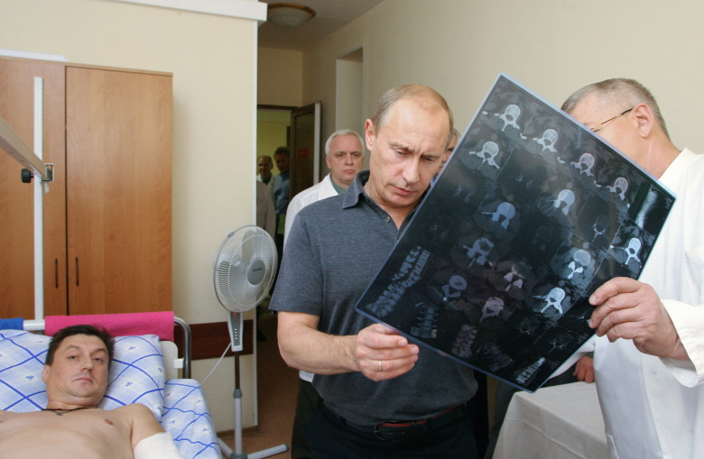 Владимир Путин беседует с врачом во время визита к раненым в Южной Осетии российским летчикам в госпитале в Москве. 23 августа 2008 года