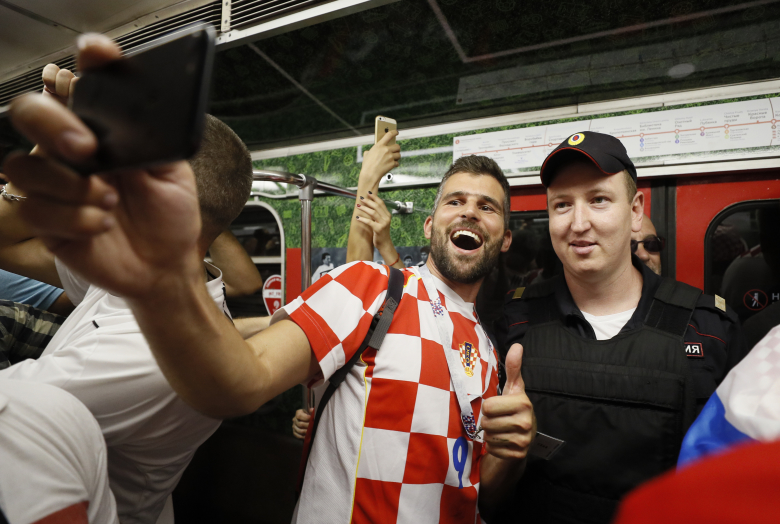 Хорватский болельщик делает селфи с полицейским в метро. Фото: Gleb Garanich / Reuters