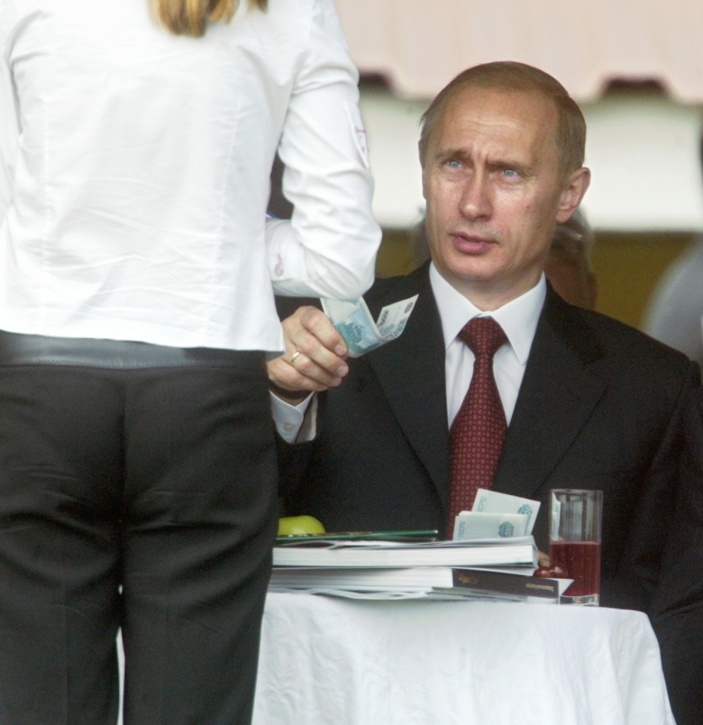 Владимир Путин делает денежную ставку на проведении первых "Скачек на приз Президента России" на Центральном Московском ипподроме. Фото: Илья Питалев / Коммерсантъ