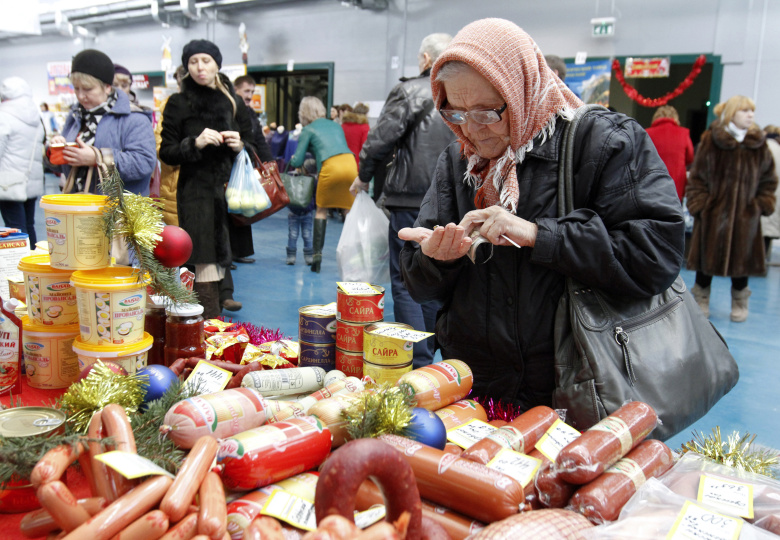 Пожилая женщина считает деньги у прилавка. Ставропольский край, РФ