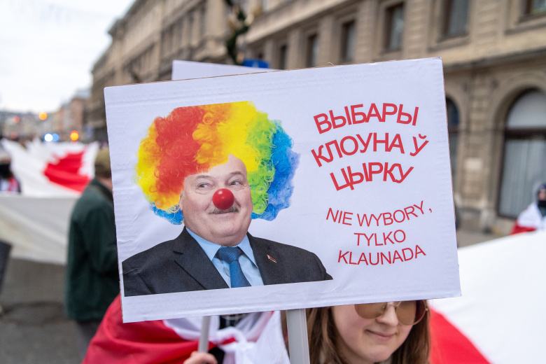 Варшава, 26 января 2025 года, участница акции протеста против перевыборов Александра Лукашенко на пост президента Беларуси держит плакат с надписью "Выборы клоуна в цирке"