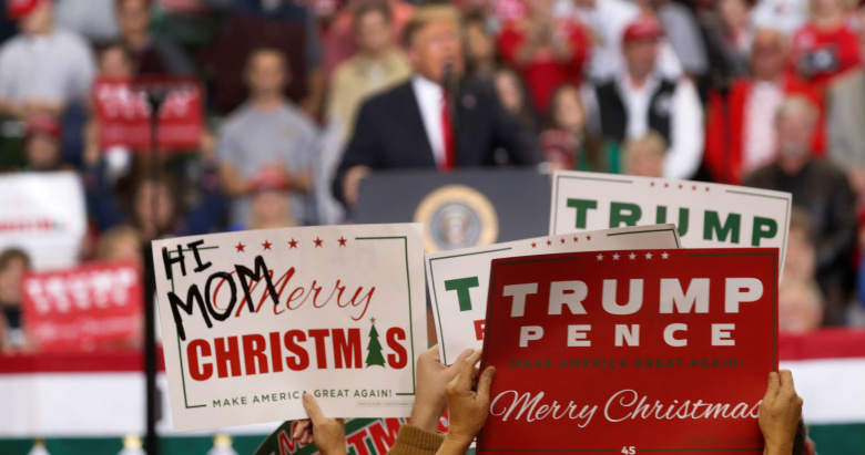 Сторонники Дональда Трампа держат плакаты во время его выступления. Фото: Kevin Lamarque / Reuters